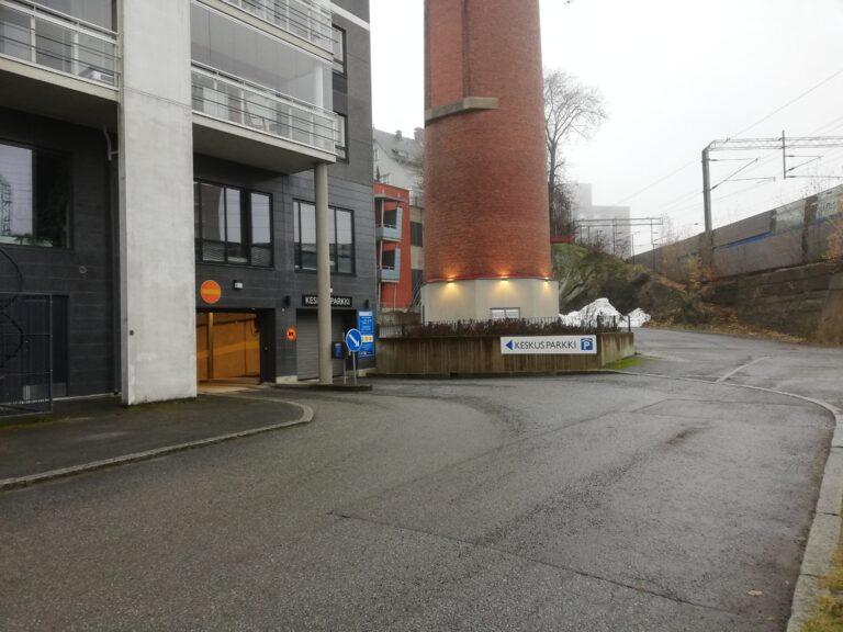 Parkkihallin sisäänajo vasemmalla kerrostalon nurkassa.