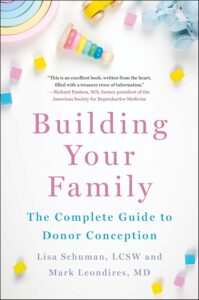 Building your family -kirjan kansi. Valkoisella taustalla pastellivärisiä pikkulasten puisia leluja.